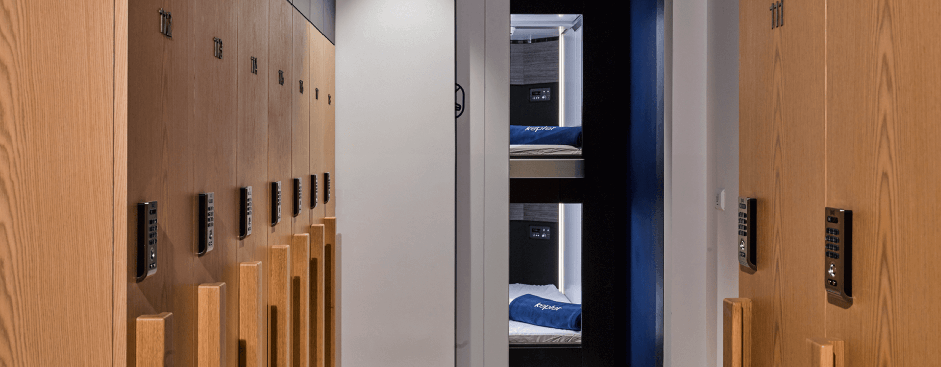 Locker room with light wood tones, featuring PIN-entry locks for secure storage, with a glimpse of our cabins in the background.