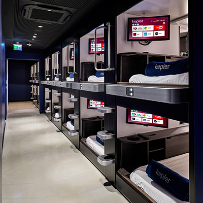 Photo of our sleeping area with a personal Kep – relax with TV, charge your phone, use your personal tablet, or open the desk to work from bed.